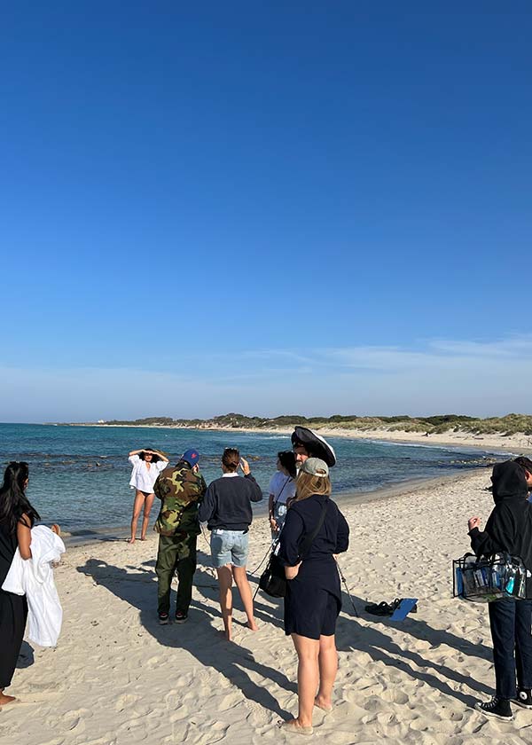 Behind the scenes of a fashion photography crew managing logistics for a beach shoot on the pristine Puglia coastline