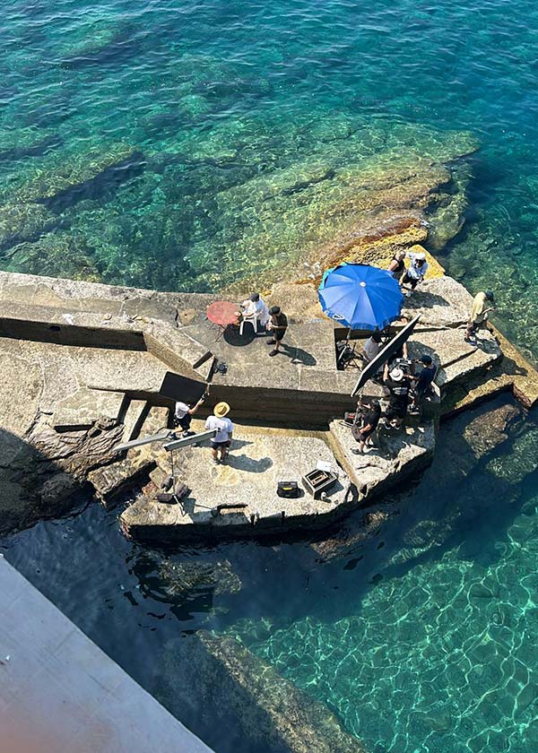 Behind the scenes of a coastal production in Liguria, showing crew logistics and equipment setup on a sea platform