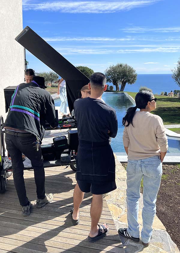 Fashion photography crew shooting at a private villa with a pool and sea horizon in Liguria, demonstrating high-end location management