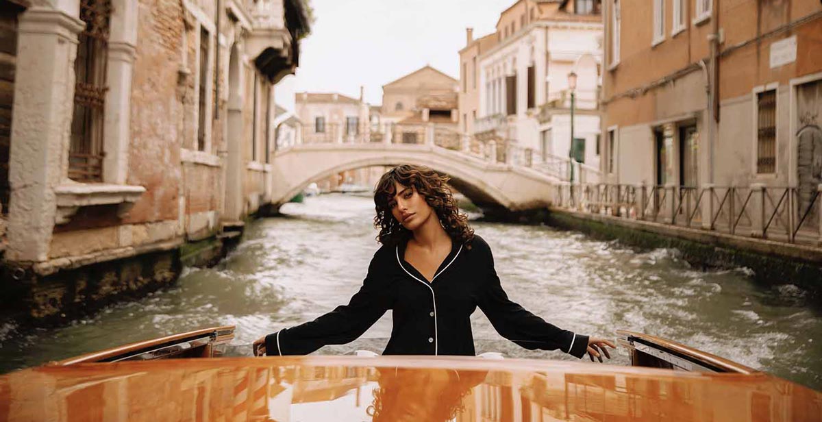 Fashion model on a classic Riva boat during a commercial photo production in Venice
